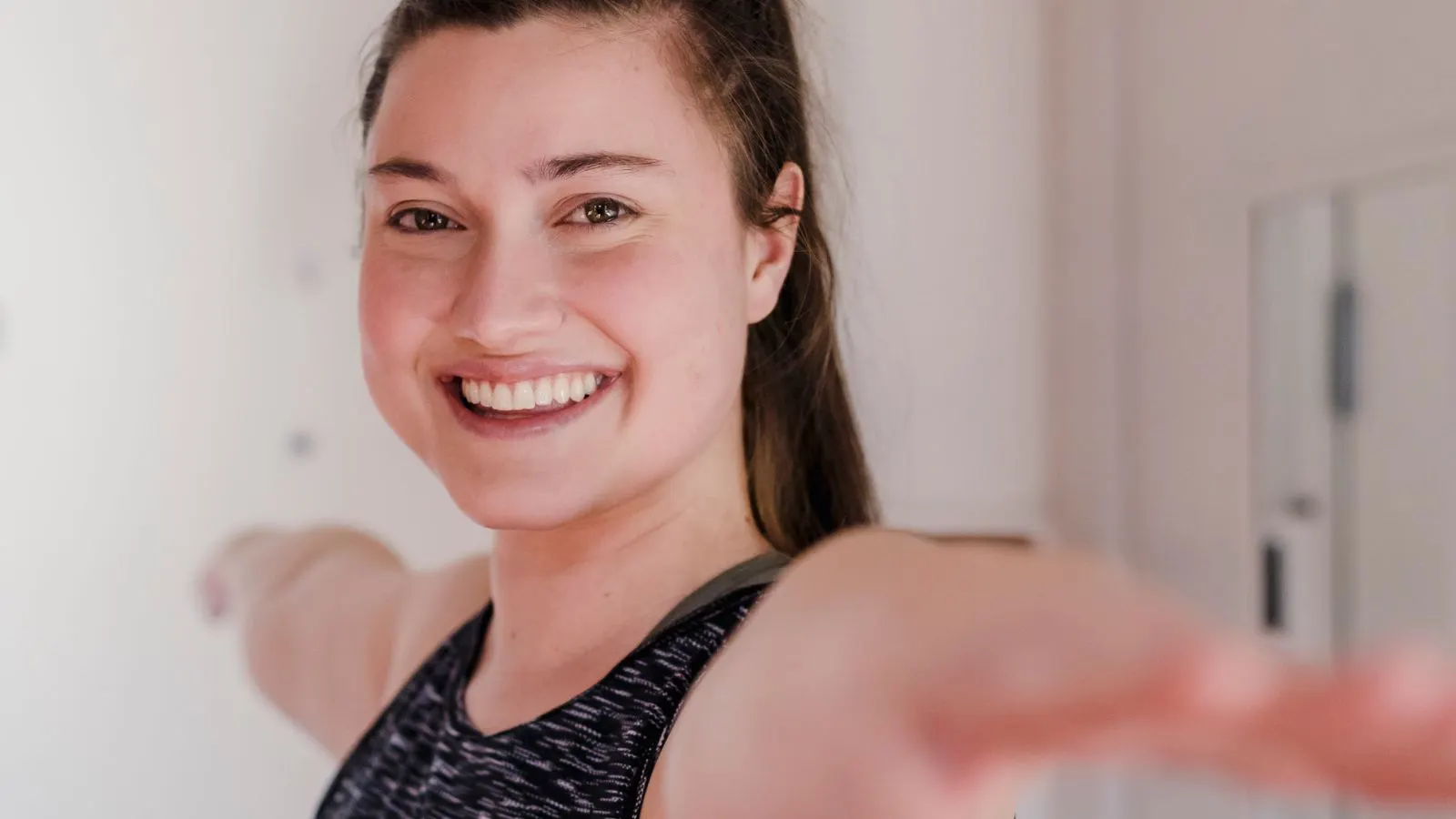 Smiling woman moving through a quick workout at home